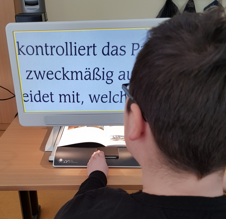Schülerin liest mithilfe eines Bildschirm-Lesegeräts